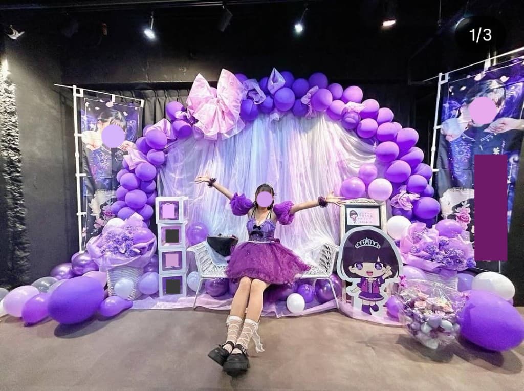紫を基調にしたバルーンアーチ、装花、衣装でそろえたイベント・ステージ装飾の写真